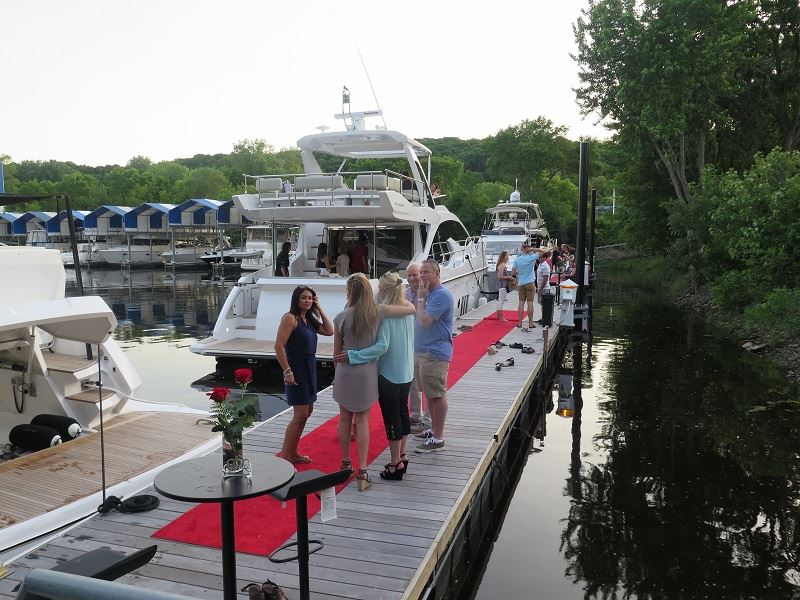 people on dock mingling on red carpet for event