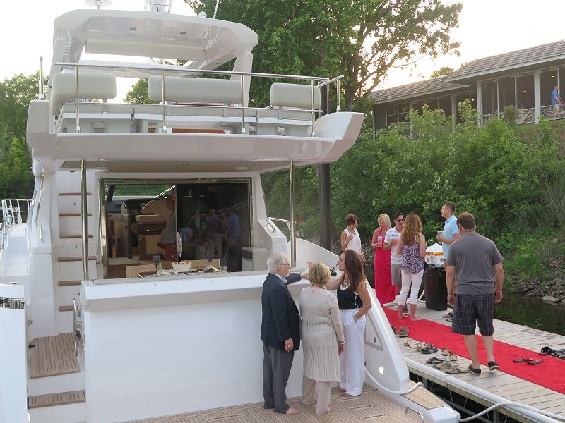 people on red carpet dock and aboard back of boat for event
