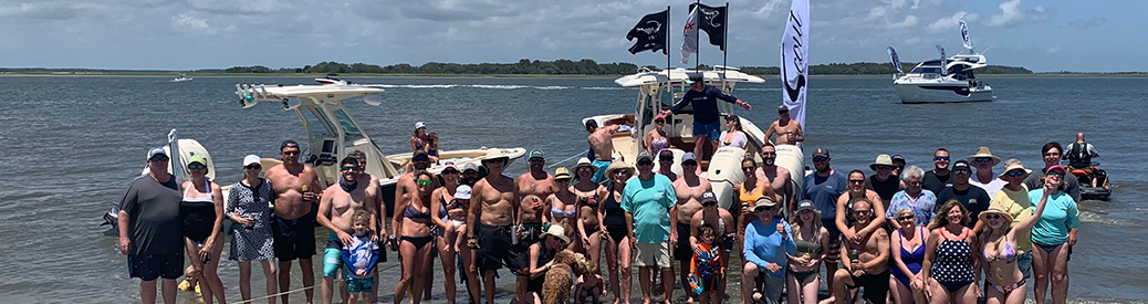 MarineMax Charleston event, large group of people at the beach and boats behind them