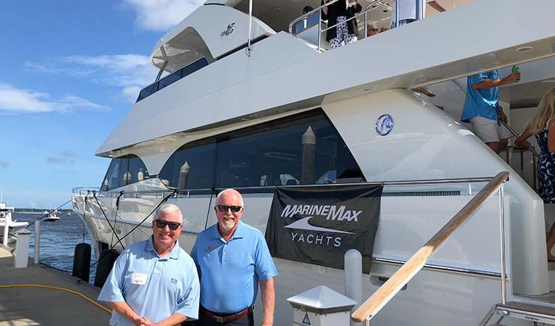marinemax charleston team members standing on a dock in front of a yacht