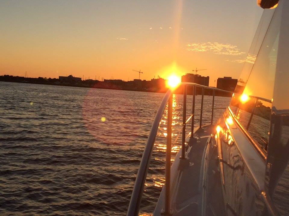 sunset view from side of boat in calm ocean waters