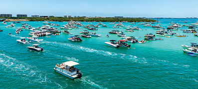 AquaPalooza 2025 logo seen with boats in the water as the backdrop, representing the annual aquatic music and fun event.