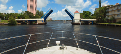 A boat heads towards an open drawbridge