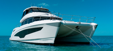 A white power catamaran idles on the water