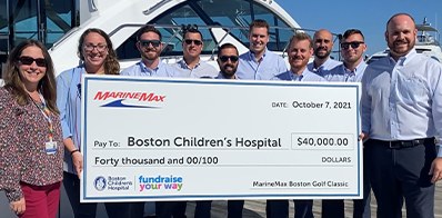 10 people holding a check to be donated to Boston's Children Hospital