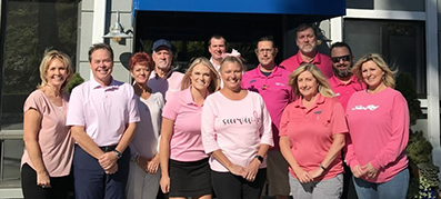 team members wearing pink outside of their MarineMax location