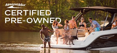 Group of people enjoying on a boat, surrounded by a lake with lush greenery. Text reads “MarineMax Certified Pre-Owned.” Fun, leisure, summer vibes.
