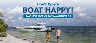 Man and women walking on the beach towards Cruisers Yachts model