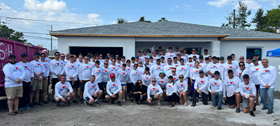 Group photo of volunteers in front of habitat for humanity house