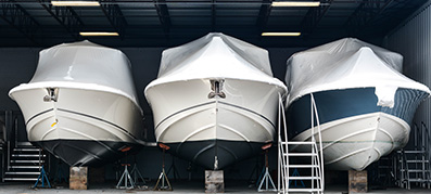 Three Boats shrink wrapped in storage