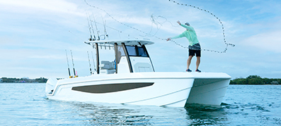 man throwing fishing net off Aquila 28 Molokai