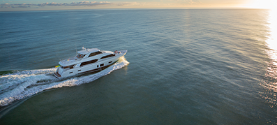 A yacht sails across the water at sunset