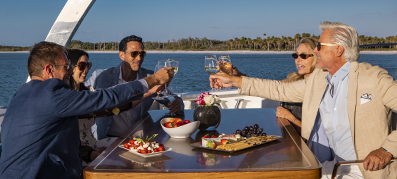 Family and friends clicking glasses around a boat