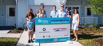 MarineMax team members pictured with the future home of the Peterson family.