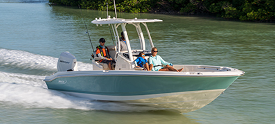 Family cruising on a center console boat through calm coastal waters.