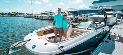 couple standing on their Sea Ray SDX 290
