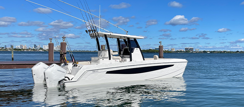 Aquila 28 Molokai next to a dock in the water