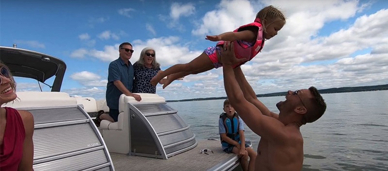 family in the water and on the aft platform of a bennington pontoon