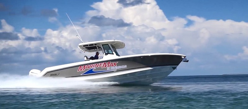 A MarineMax Boston Whaler cruises through the water from left to right.