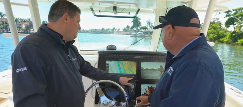 Two men using a Raymarine screen on a boat