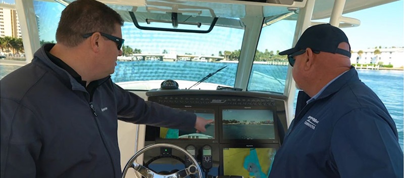 Two men pointing at a boat navigation screen