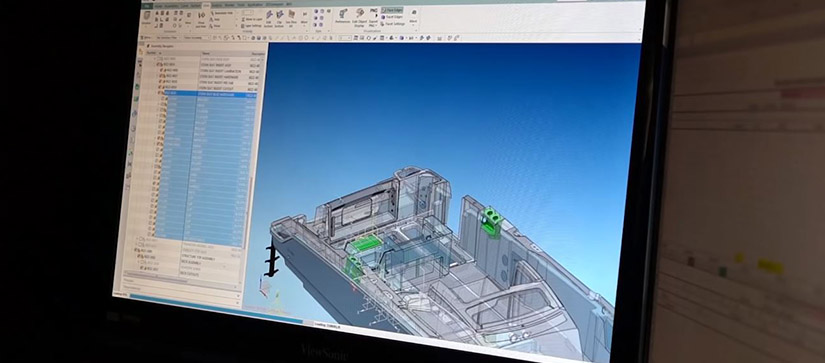 A computer screen shows a boat design