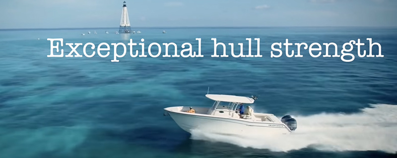 Boat cruising through the water with "Exceptional hull strength" written in white font - Grady White, The Ultimate Boating Experience Video