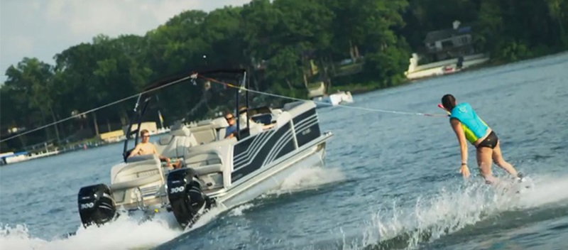 girl wakeboarding behind a pontoon