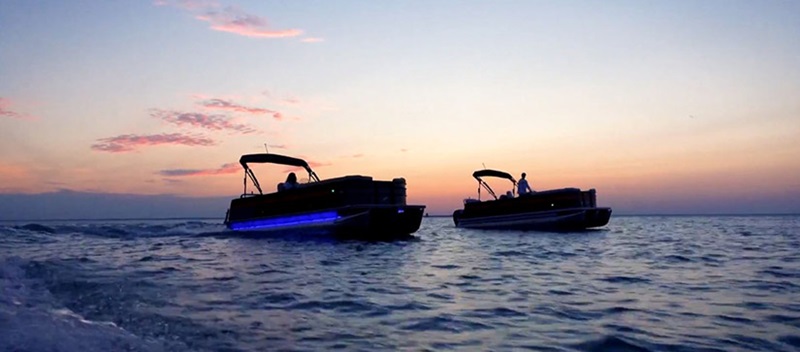 two pontoons on the water at sunset