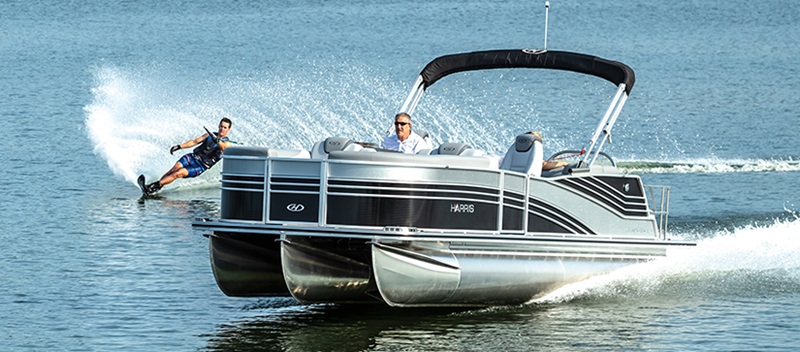 Harris Grand Mariner Pontoon out on the water with a wakeboarder behind