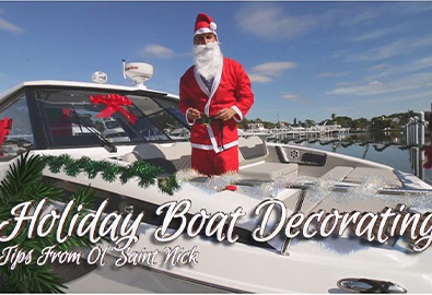 A man in a Santa Claus costume standing aboard a decorated boat