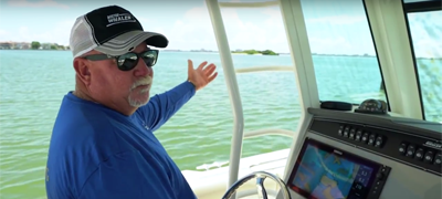 Man driving a boat and pointing out - Learn to read channel markers