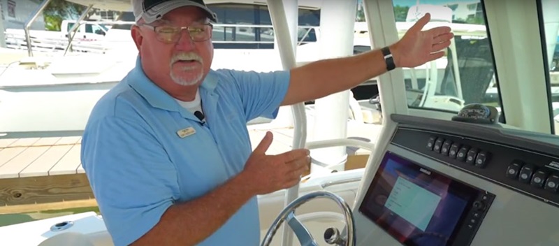 Man by the helm of a boat talking - Boating Tips Video on Simrad Chartplotters