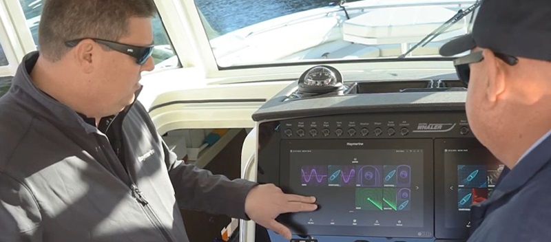 A man pointing at a touch screen navigation system on a boat