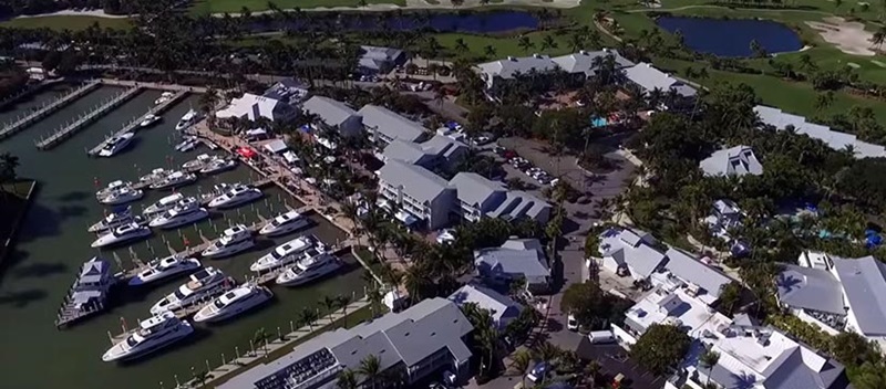 overhead the South Seas Island Resort with several yachts in the water tied to the dock, buildings, and golf course. 