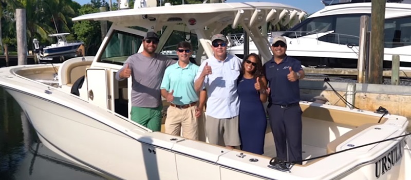 Customers and MarineMax Miami team on new boat smiling