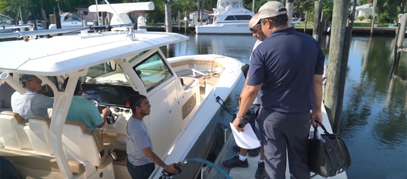 Men on board of a boat talking to men on the dock - MarineMax Miami Service Team Is Committed to You and Your Boat
