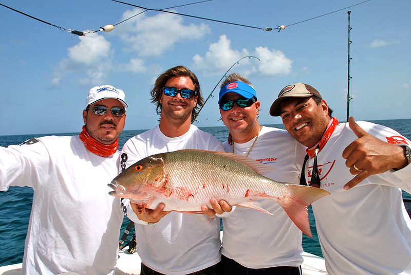 Four men holding a fish - MarineMax Boaters