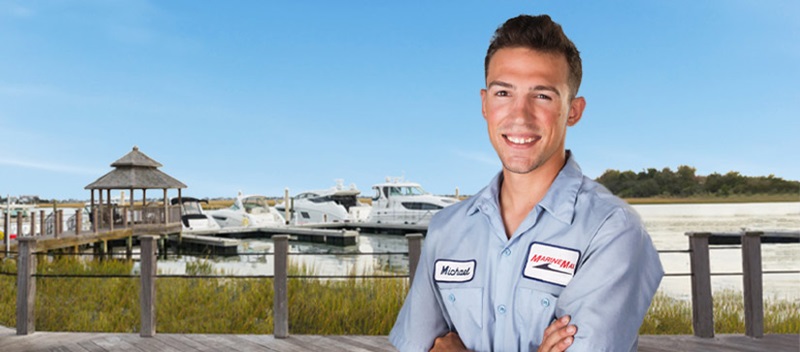 MarineMax technician with a dock in the background
