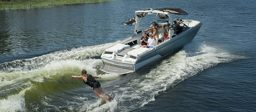 A wakesurfer trailing behind a Nautique