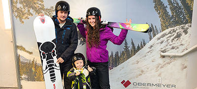Family posing for photo with snowboards