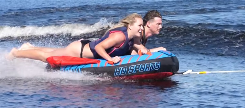 Man and Woman tubing in open water.