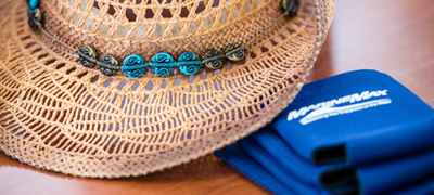 Hat on table with MarineMax Vacations Koozies