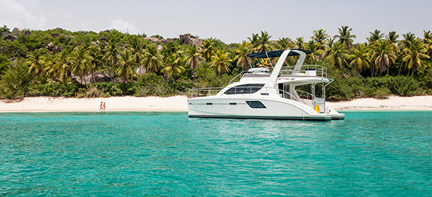 An Aquila power catamaran close to the shore of a beach