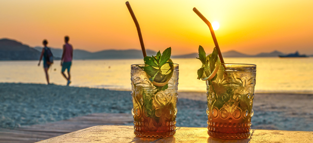 Glasses with rum in it with beach sunset in the background