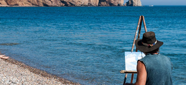 Artist painting by coast