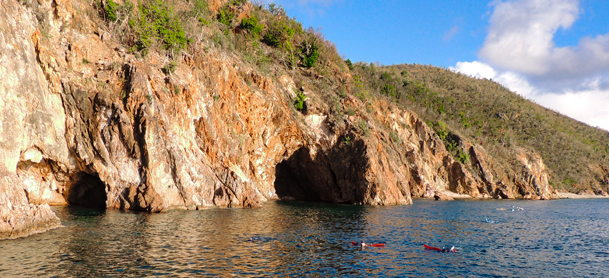 People kayaking by caves