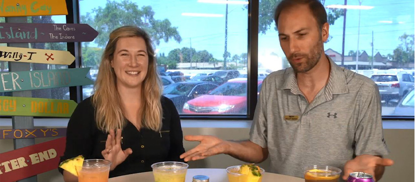 Two MarineMax team members at a table with four cocktails