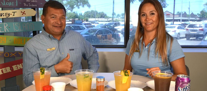 Two MarineMax team members at a table with four cocktails
