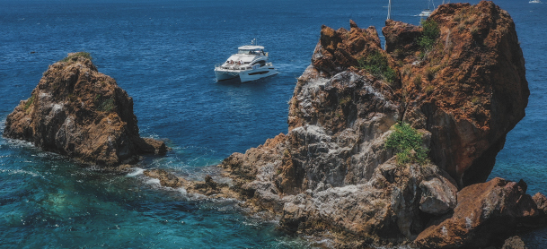 top view of rocks in the water with charter in the background